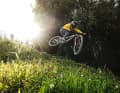 Lass fliegen! Das Propain Spindrift in der Doppelbrücken-Variante im lowlevel flyby auf der UCI Downhillstrecke im Bikepark Leogang.