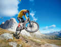 Will springen, spielen, will schnell fahren: das brandneue Santa Cruz Nomad 6. Im Hintergrund: die Sella-Türme. Checkt den Flieger!