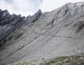 Und plötzlich steht diese zu Fels erstarrte Gischtwelle vor dir: der 2936 Meter hohe Col Malatrà. Auf den letzten 70 Metern hilft ein Seil durch die Felslücke.