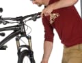 Sitzt der Bremssattel schief, schleifen die Beläge an der Scheibe und nutzen sich ungleichmäßig ab. Ziel ist es, dass auf beiden Seiten der Bremsscheibe ein minimaler Abstand zu den Belägen bleibt. Bei der Montage mit IS2000-Standard erreichen Sie dies mit hauchdünnen Unterlegscheiben, die im Lieferumfang der Bremse enthalten sind (ansonsten im Fachhandel). Deutlich einfacher funktioniert die Justage bei Bremsen mit Langlochbefestigung, da die sogenannte Postmount-Befestigung Korrekturen erlaubt. Lösen Sie hierzu die Schrauben für den Bremssattel so weit, dass dieser sich bewegen lässt. Ziehen Sie nun den Bremshebel, die Bremse richtet sich automatisch mittig an der Scheibe aus. Halten Sie den Bremshebel weiter fest, während Sie die beiden Schrauben wieder vorsichtig festziehen.