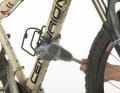 6. Nehmen Sie anschließend eine Bürste mit langen Borsten zur Hand. Hier tut es auch ein kleiner Handfeger. Schrubben Sie damit den hartnäckigen Dreck vom Mountainbike. Spülen Sie die Bürste zwischendurch ordentlich aus, damit Steinchen und Sand sich nicht in den Haaren der Bürste verfangen und Sie damit Kratzer in den Lack reiben.