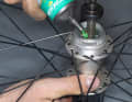 NABEN PFLEGEN
Schritt 1: Achslager schmieren

Die Schmierung der Lager ist meist nur bei Shimano- Naben nötig. Hat ihre Nabe eine “Centerlock”- Befestigung für die Bremsscheibe, sollten Sie die Bremsscheibe demontieren. Öffnen Sie die Konterung der Naben. Entfernen Sie Kontermutter, Distanzscheiben und Lagerkonus. Dann können Sie die Achse herausziehen. Befreien Sie die Lagerlaufflächen und Kugeln von altem Fett und Dreck. Danach setzen Sie die Kugeln wieder ein und belegen sie mit einer frischen Fettpackung. 
