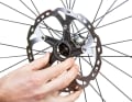 CENTERLOCK-MONTAGE

 Setzen Sie die Centerlock-Scheibe auf die Verzahnung an der Achse. Achten Sie auf die Laufrichtung: Die Schrift auf der Scheibe muss nach außen zeigen.