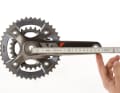 KURBELLÄNGE
Kleine Leute, kleiner Rahmen: Auch die Kurbellänge sollte angepasst werden.

Gemessen wird die Kurbellänge von der Mitte der Tretlagerachse bis zur Mitte der Pedalachse. Am häufigsten sind 175-mm-Kurbeln verbaut, gefolgt von 170ern. Hochwertige Kurbelsysteme, wie die XTR-Kurbeln, bietet Shimano in 2,5-mm-Schritten an.
Kürzer oder Länger? Einflussfaktoren auf die optimale Länge gibt es viele: Körpergröße, Schrittlänge, Vorlieben. Falls Sie nicht mit der Standard-Kurbel zurechtkommen, sollten Sie etwas unternehmen. Dabei gilt: Große (ab 1,90 m) und sportliche Fahrer greifen zur längeren Kurbel, kleine (unter 1,70 m) und mit hoher Trittfrequenz kurbelnde Biker wählen die kürzere Variante.
Bei Knieproblemen sollten Sie kürzere Kurbeln ausprobieren, da so der Bewegungsumfang verringert wird. Fahrer, die gern mit dicken Gängen und niedriger Trittfrequenz in die Pedale treten, sind mit längeren Kurbeln besser beraten, weil die Umlaufstrecke dadurch zunimmt. Nach dem Umstieg aktivieren Sie ungewohnte Muskelbereiche: also langsam beginnen!