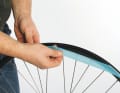 Der erste Schritt ist, die Felge für die Umrüstung vorzubereiten. Dazu eventuell vorhandene Felgenbänder oder ältere Tapes entfernen. Bei Kleberückständen unbedingt die Felge mit Bremsenreiniger oder Ähnlichem reinigen. Nur so haftet das Abdicht-Tape überall fest auf der Felge.