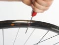 Liegt das Tape vollflächig an, macht man sich an die Montage des Schlauchlosventils. Zuerst durchsticht man dazu das Tape mit einem kleinen Schraubendreher oder ähnlich spitzem Werkzeug. Danach drückt man das Ventil von außen durch das vorgebohrte Loch.