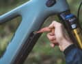 Löst man für die Akku-Entnahme das Cover vom Unterrohr des Yeti 160E T1, wird ein kleiner Spalt frei, um den Akku an einer Klinke für die Entnahme zu entsichern. Biker ohne Spinnenfinger gelangen nur mit Nachdruck an den Sicherungshaken.