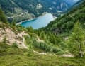 Hinter der Geländestufe warten aber nicht nur neue technische Herausforderungen, sondern auch der Blick aufs noch weit entfernte Trail-Ende. Das befindet sich direkt am Ufer des Lago di Pian Palu. Anschließend folgt man der Talstraße, die bis zum Grund des Val di Sole aber noch einen Trail-Abzweig in petto hat.
