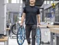 Labormitarbeiter Lars Funke trägt zwei massive Aluräder zum Prüfstand. Neue Mountainbike-Compounds werden zuerst auf Rennradreifen vulkanisiert. Das eliminiert den Einfluss des Profils auf die Labormessungen.