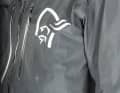Das große Norrøna Logo reflektiert, so wie alle anderen hellen Applikationen auf der Norrøna fjørå Regenjacke..