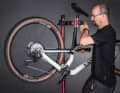 1. Bike aufhängen: Ein Montageständer ist ein idealer Helfer beim Einstellen der Schaltung. Wer keinen hat, hängt das Bike mit dem Sattel an eine Stange. So kann man mit der linken Hand an der Kurbel drehen und mit der rechten den Schalthebel bedienen.
