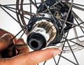 Auslöser Ritzelpaket: Demontiere die Zahnkränze komplett, reinige vor allem die Kontaktflächen und das Gewinde des Abschlussrings gründlich. Das Gewinde und den Freilaufkörper dünn einfetten. Kassette wieder montieren und mit dem angegebenen Drehmoment anziehen.