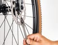 Vor allem Shimanos IceTech-Scheiben verformen sich leicht unter Hitze- oder Krafteinwirkung, ein metallisches “Zing” bei jeder Radumdrehung ist die Folge. Tritt das Geräusch nur nach starken Bremsungen auf und verschwindet nach kurzer Zeit wieder, besteht kein Handlungsbedarf. Geht es nicht weg, stellen Sie zunächst die Bremse neu ein. Reinigen und mobilisieren Sie die Kolben, damit sie sich wieder sauber zurückstellen. Reicht das nicht, können Sie versuchen, eine verbogene Bremsscheibe mit einem passenden Werkzeug zu richten.