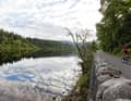 Spiegelbild: Eine verschlungene Straße führt durch den Märchenwald der Trossachs, inklusive See- und Himmelblick wie hier am Loch Achray.