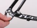 Verlegen Sie von dort die Kabel zu den Schaltelementen. Aufkleber mit „RD“ für „Rear Derailleur“ (Schaltwerk) und „FD“ („Front Derailleur“) für den vorderen Umwerfer lassen keine Verwechslung zu. Fixieren Sie den Kabelbaum mit Kabelbindern so am Rahmen, dass Reifen, Kurbeln und Ihre Fersen nicht scheuern oder hängenbleiben.