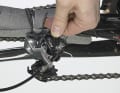 5. Halten Sie das Schaltwerk mit einer Hand fest, damit es nicht herunterfällt, lösen Sie die Schraube und demontieren Sie es. Schützen Sie die Kettenstrebe entweder mit Luftpolsterfolie oder Schaumstoffrohren (z.B. von Warmwasserrohren). Binden Sie das Schaltwerk in die Mitte der geschützten Strebe.