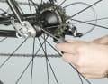 1. Bei Campagnolos Systemlaufrädern verbirgt sich der Einstellring unter einer Kunststoffkappe. Lösen Sie diese mit einem spitz zulaufenden Werkzeug, zum Beispiel einem Messer. Verkanten Sie das Werkzeug dabei nicht, sonst gibt’s Kratzer. 
