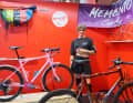 Éliane Trudeau von Memento Cycles zwischen den zwei Ausstellungsrädern des Rahmenbau-Teams.