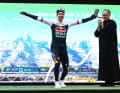 Primoz Roglic feiert den Tagessieg mit seiner typischen „Telemark-Landung“ aus dem Skispringen auf dem Podium.