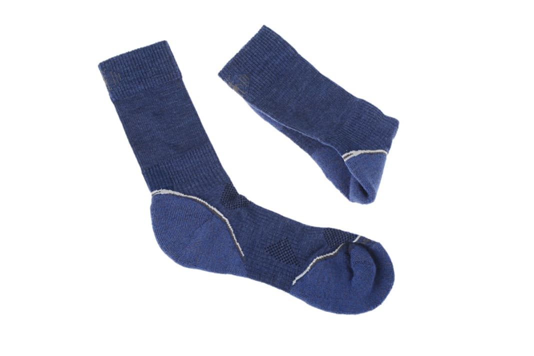 Icebraker Merino Mens Hike Mid Crew: Die simple Grundregel lautet: Ein Luftpolster isoliert gegen Kälte. Der Fuß ­bleibt länger warm, wenn zwischen ihm und dem Schuh Platz bleibt für eine Luftschicht. Als Dämmschicht mit gutem Feuchtigkeitstransport ­be­währen sich Wander- oder Ski-Socken aus Merinowolle mit einem Anteil an Funktionsfasern. Die geruchsneutrale Wolle wärmt, die beigemischte Kunst­faser hält die Socke in Form, lässt sie schnell trocknen und macht sie wasch­­maschinenfest. Bezug/Info www.icebreaker.com - Preis  26 Euro