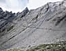 Und plötzlich steht diese zu Fels erstarrte Gischtwelle vor dir: der 2936 Meter hohe Col Malatrà. Auf den letzten 70 Metern hilft ein Seil durch die Felslücke.