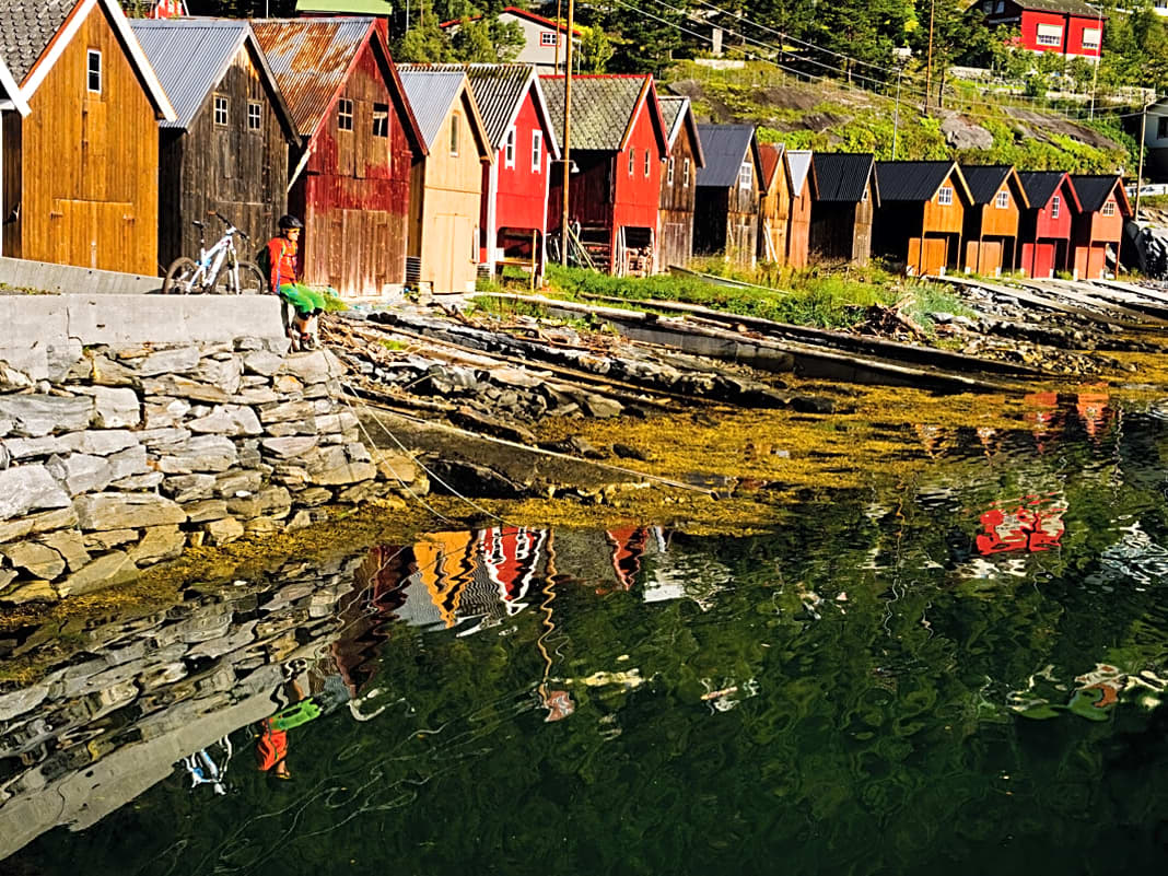 Bunte Bootshäuschen säumen die Ufer in den Fjorden