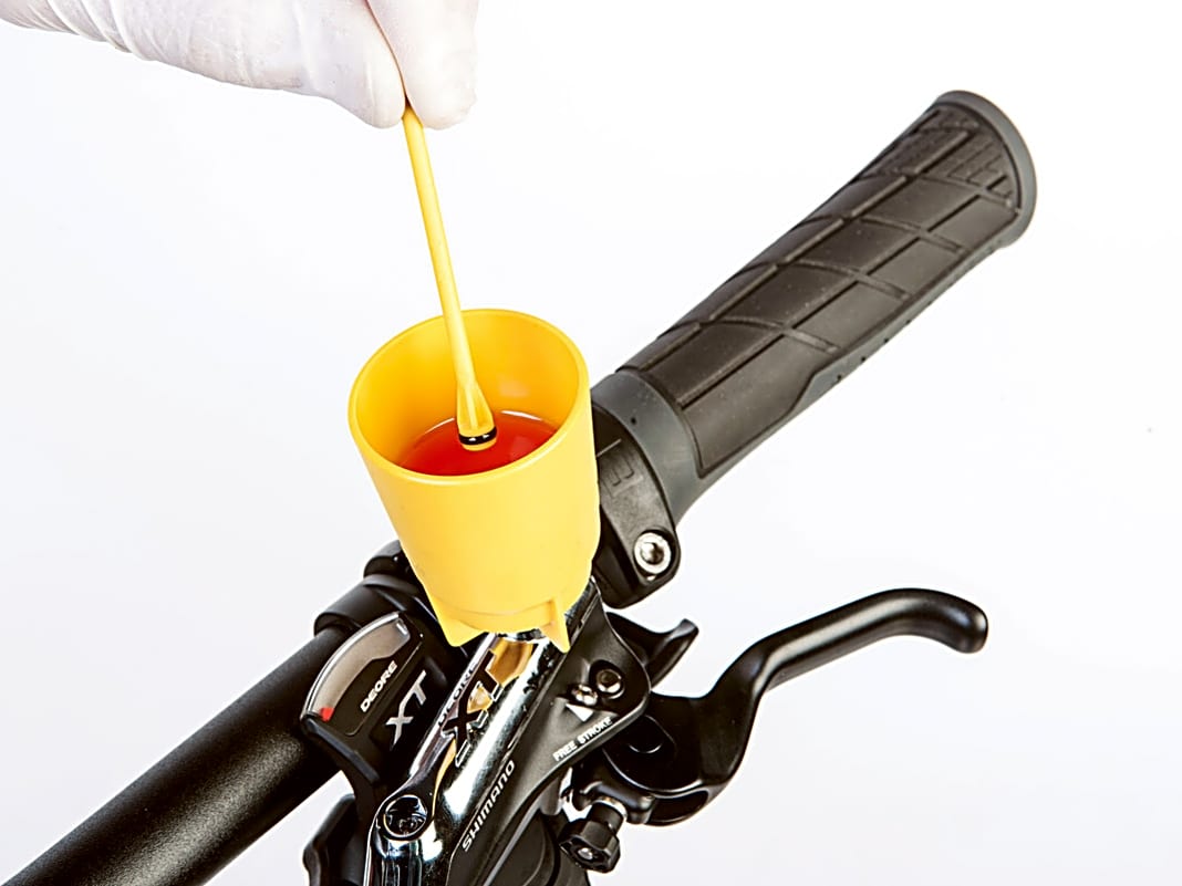 Beim Ziehen der Bremse sollte der Druckpunkt jetzt hart sein. Setzen Sie dann den Ölstopper in den Ölbehälter ein und entfernen Sie den Behälter vom Bremshebel.