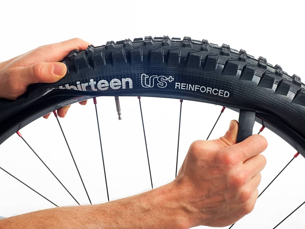 2. Um den Fahrradschlauch zu wechseln, reicht es, den Reifen nur auf einer Seite aus der Felge zu hebeln. Beginnen Sie am Ventil und arbeiten Sie sich entweder durch Schieben (Bild) oder Ziehen weiter vor, bis sich der Reifenwulst aus der Felge löst.