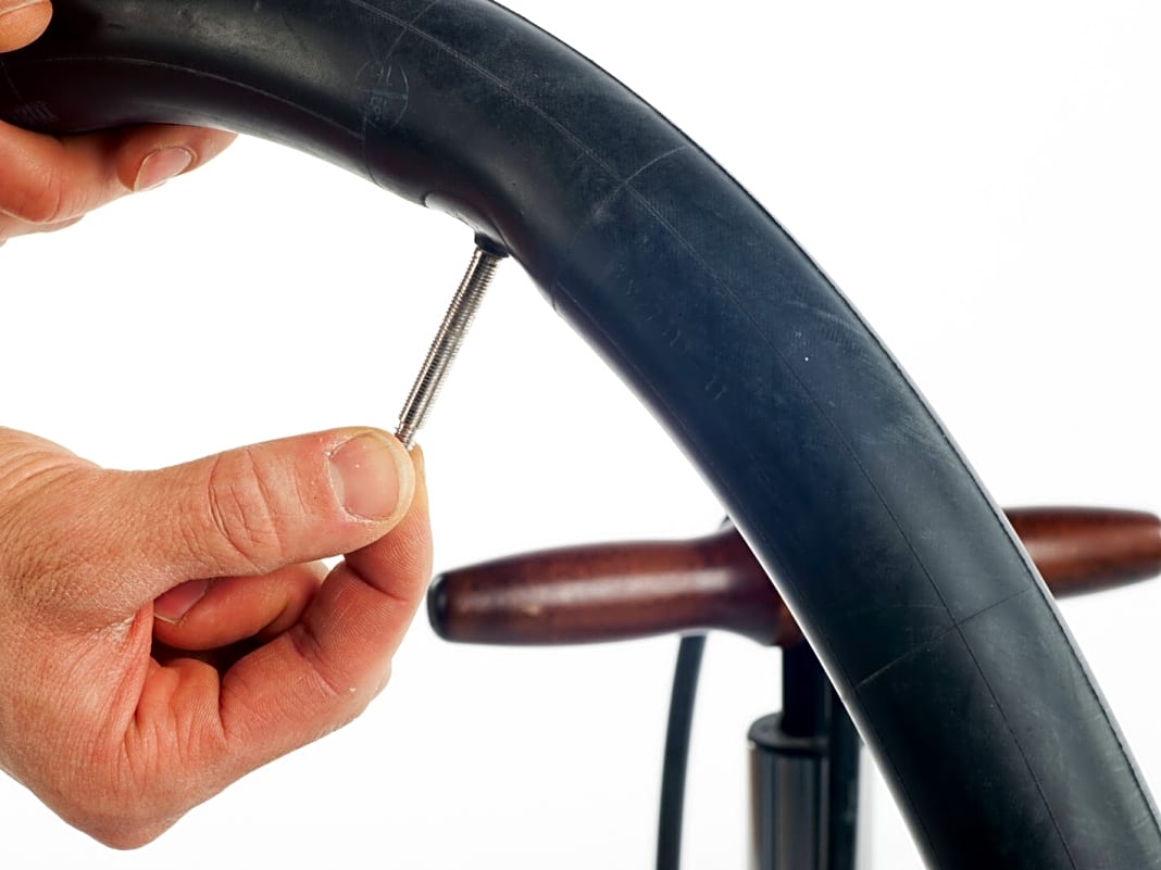4. Pumpen Sie den neuen Fahrradschlauch an, damit er sich nicht verknotet oder verdreht und drehen Sie das Ventil wieder zu. Er sollte nur so weit aufgepumpt werden, dass er keine Knicke mehr aufweist, sich aber noch gut einlegen lässt. 