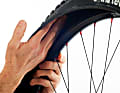 3. Entfernen Sie den defekten Fahrradschlauch und suchen Sie den Reifen innen (durch Tasten mit der Hand) und außen auf Fremdkörper ab. Dornen, Steinchen oder ähnliches müssen entfernt werden, bevor Sie den neuen Schlauch einlegen.  