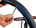 4. Pumpen Sie den neuen Fahrradschlauch an, damit er sich nicht verknotet oder verdreht und drehen Sie das Ventil wieder zu. Er sollte nur so weit aufgepumpt werden, dass er keine Knicke mehr aufweist, sich aber noch gut einlegen lässt.  