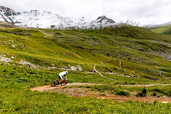   Im Angesicht der Silvretta: Der angelegte Singletrail nach Samnaun windet sich durch blühende Bergwiesen.
