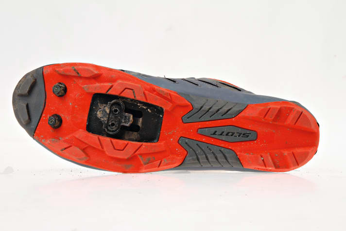   Die Nylon-Sohle am <a href="https://www.awin1.com/cread.php?awinmid=12557&awinaffid=471469&clickref=B+Schuhe+Scott+MTB+Team+Boa&ued=https%3A%2F%2Fwww.bergzeit.de%2Fscott-herren-mtb-team-boa-radschuhe-yellow-black-eu-41" target="_blank" rel="noopener noreferrer nofollow">Scott MTB Team Boa</a> * ist zwar nicht ultimativ steif, dafür ist sie auch für kurze Schiebepassagen ausreichend profiliert.