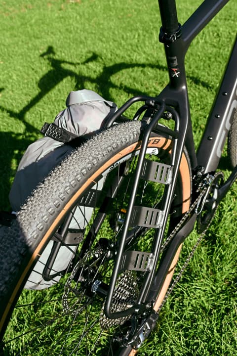 Das steife Adventure Rack gibt’s für rund 40 Euro als Zubehör, es nutzt die Gepäckträgeraufnahmen für zwei smart vertäute Drybags. Top!
