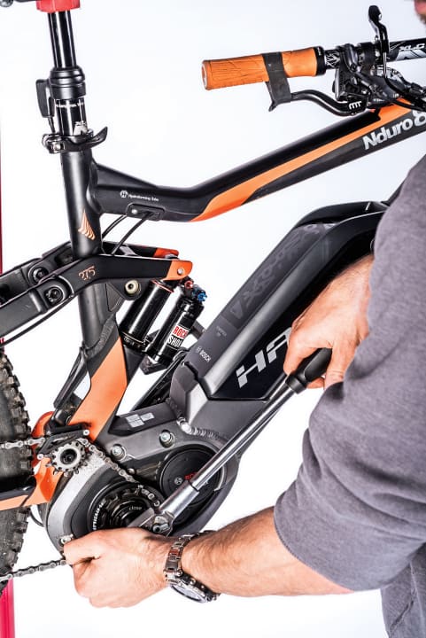    2 Mit Bosch-Spider-Tool öffnen: Das im Fachhandel erhältliche Bosch-Tool hat zwei Drehrichtungen. Um den Lock-Ring zu öffnen, ist das Tool nach rechts zu drehen, allerdings läuft dann der Motorfreilauf mit. Bei vielen Bikes ist der Lock-Ring unserer Erfahrung nach jedoch mit geringem Kraftaufwand zu öffnen. Falls nicht, fixieren Sie die gegenüberliegende Kurbel (keine Angst, die Kraft geht auf das Stahl-Vorgelege, es schadet dem Motor nicht). Alternativ dazu Kette aushängen, und Ritzel mit Kettenpeitsche fixieren.